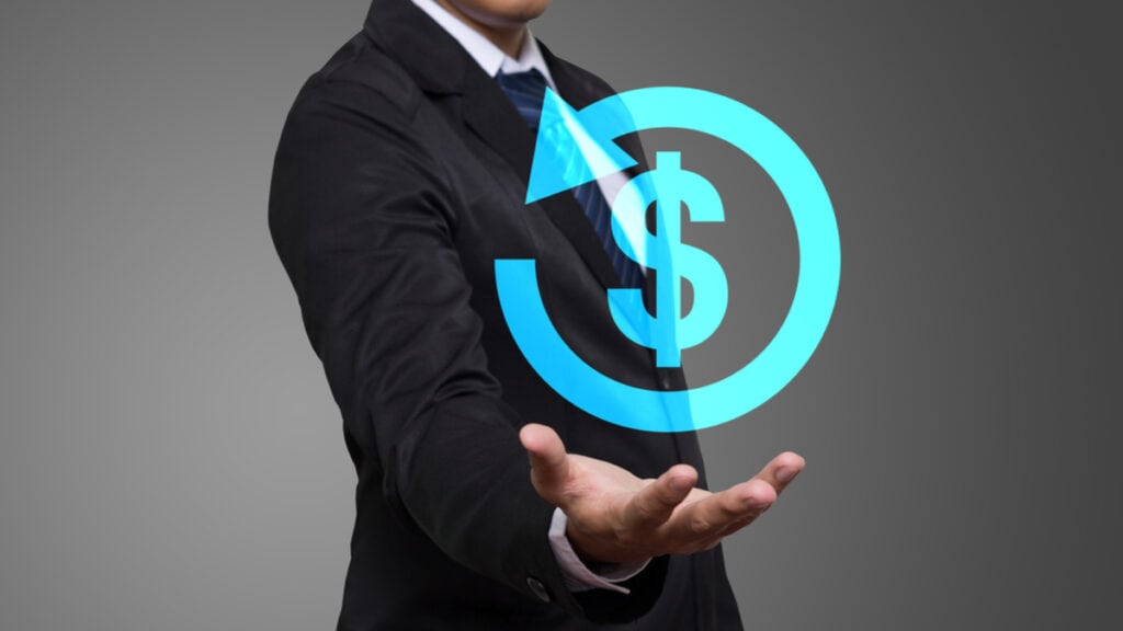 Homem estende a mão para frente. Acima da sua mão, há um símbolo de cifrão e uma setinha ao redor, ambos na cor azul claro. A intenção é simbolizar o processo de como contestar um chargeback.