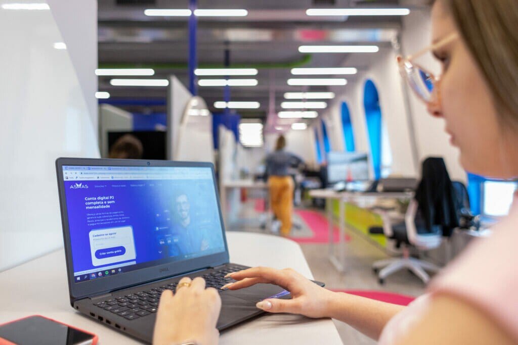 foto de uma menina em frente a um notebook mostrando a nota fiscal asaas