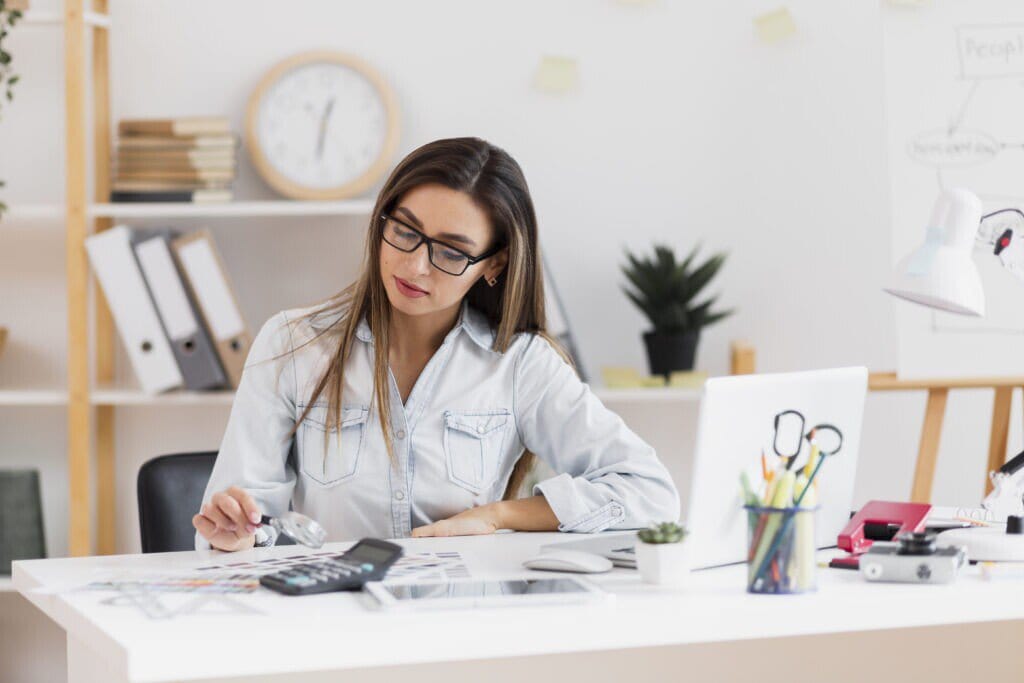 Empresária em seu computador. Ela está pesquisando sobre gestão financeira para escritório de arquitetura.