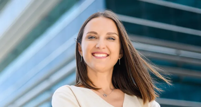 Mulher branca sorri após contratar sistema de gestão de cobranças.