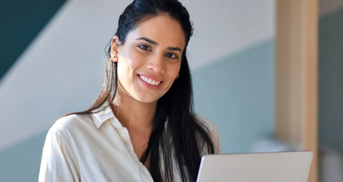 Mulher branca sorri após fazer boa gestão financeira.