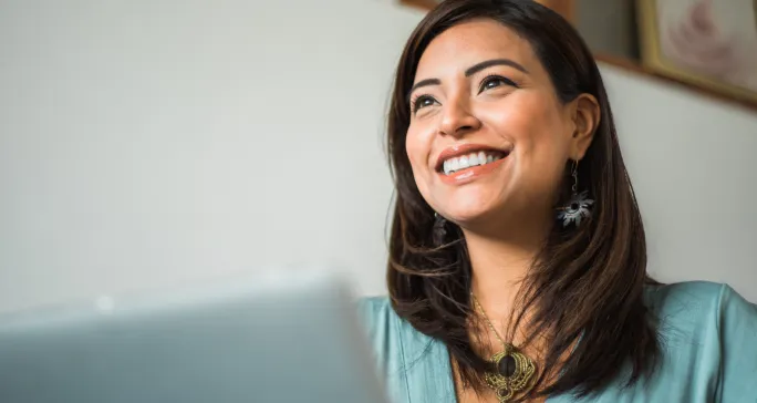 Mulher asiática olha para frente sorrindo após emitir nota fiscal.