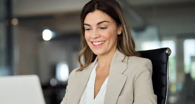 Mulher branca sorri após fazer boa gestão de pagamentos.