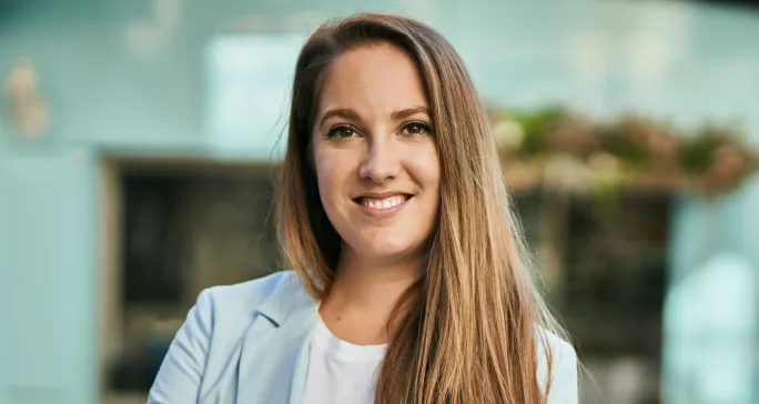 Mulher loura sorri, pois achou segurança no Asaas.