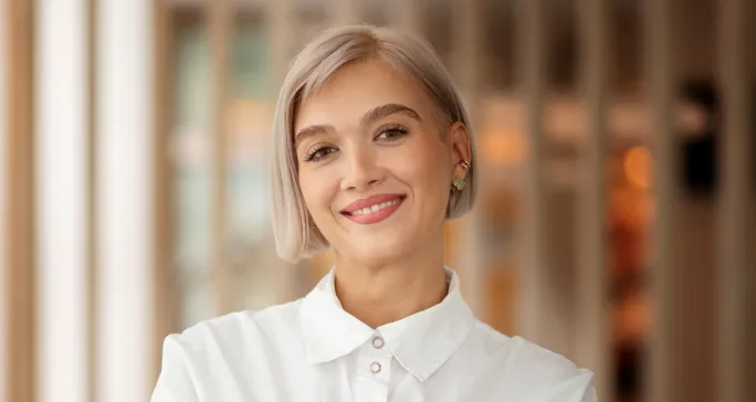 Mulher loura sorri após conhecer a tecnologia do Asaas.